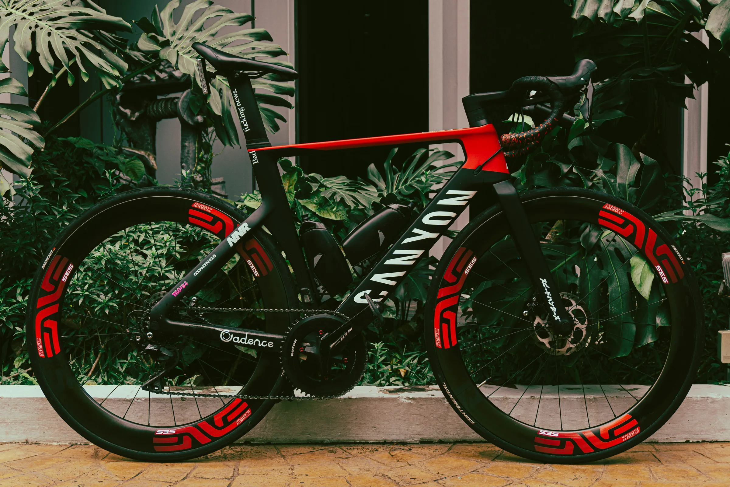 Black aero road bike with red rim graphics