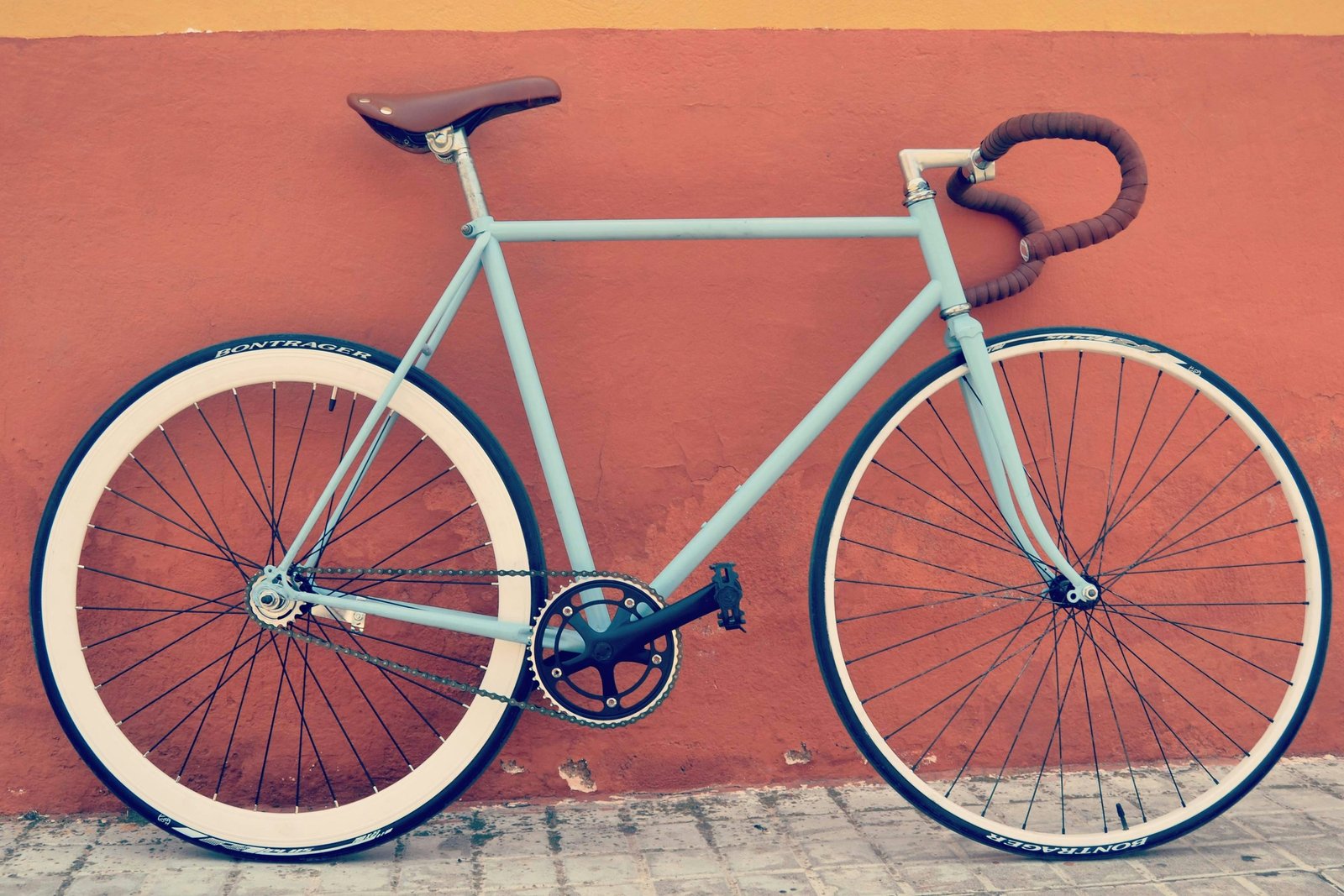 Mint road bicycle against a coral wall