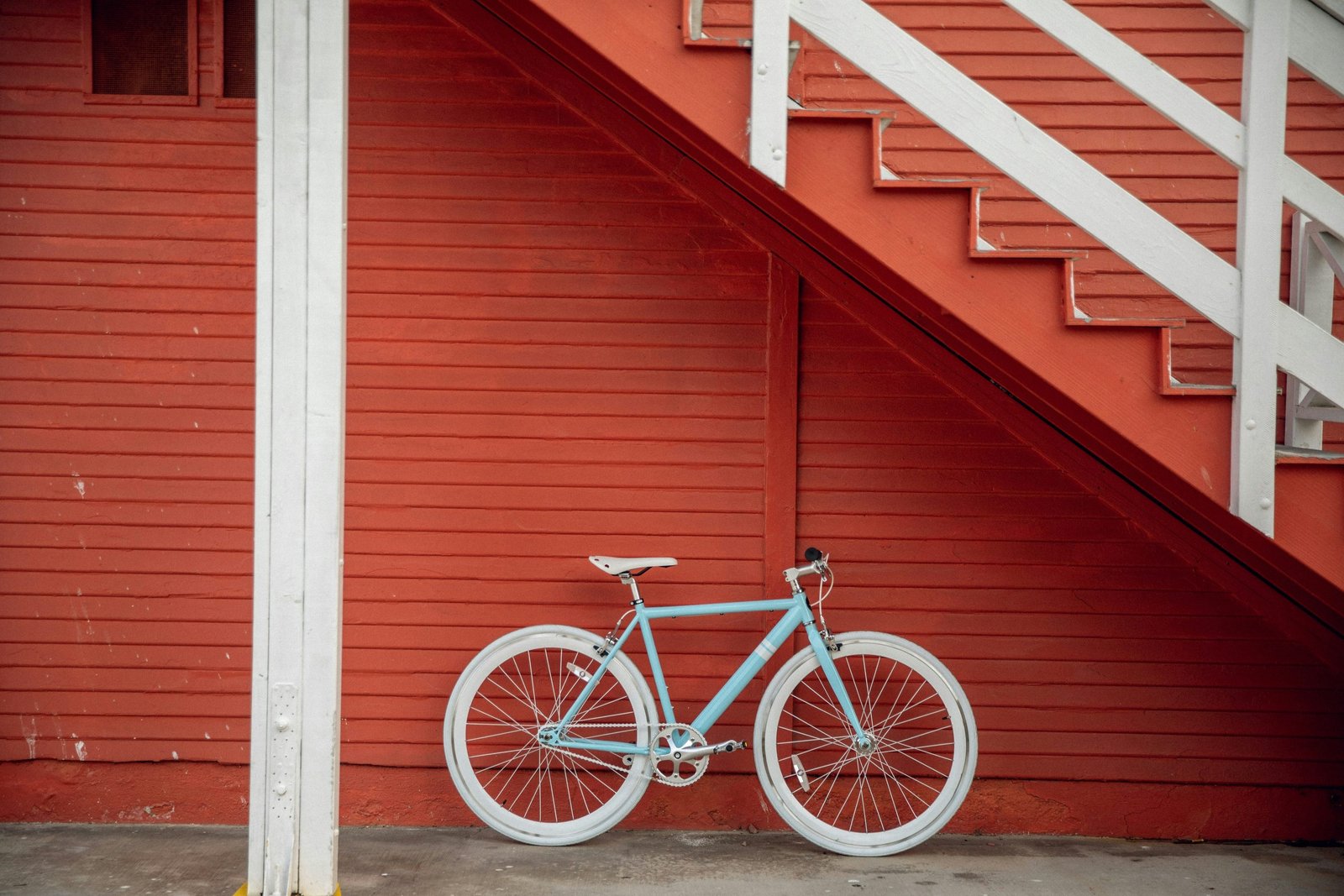 Light city bike parked against a red staircase